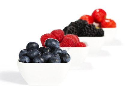 食物颜色无刺莓蓝放在碗里其他浆果放在背景中蓝莓放在碗里其他野生浆果放在碗里背景是白色图片