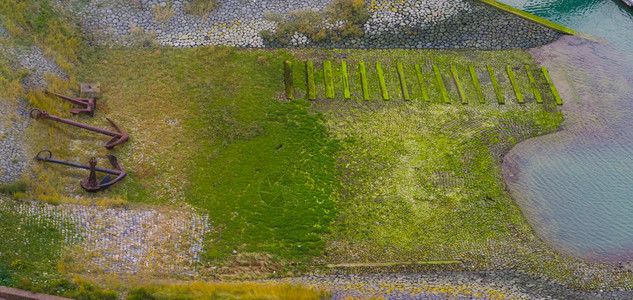 镜头荷兰语Vlissingen港湾堤岸的空中绿海草覆盖着石头装有船锚饰杜奇风景图片