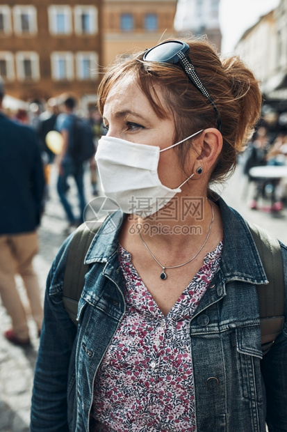 流行病人群站在市区街头的年轻女子站立在街上望着身戴面罩的一边以避免感染防止疾病在出现冠状腺毒时蔓延保护图片