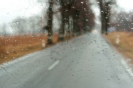 抽象的外部风暴在大雨中驾车高速公路上汽车玻璃的雨滴湿沥青图片