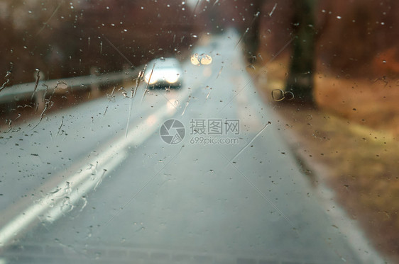 驾驶在大雨中车高速公路上汽车玻璃的雨滴湿沥青下红色的图片