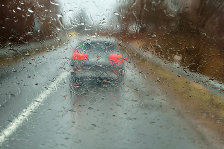 水加里宁格勒降低在大雨中驾车高速公路上汽车玻璃的雨滴湿沥青图片