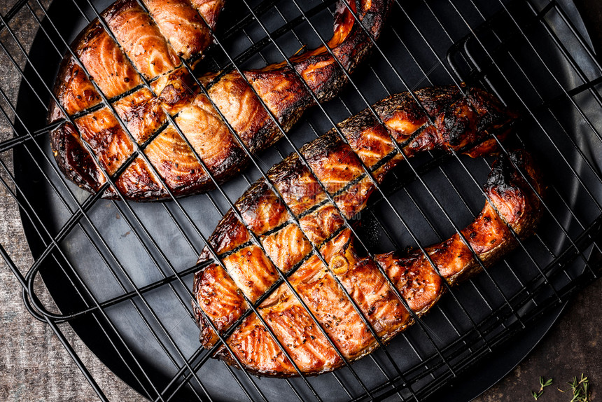 小吃铁烧烤格网上的灰鲑鱼在暗底背景最深的视野下BBQ海产食品准备好的海鲜图片