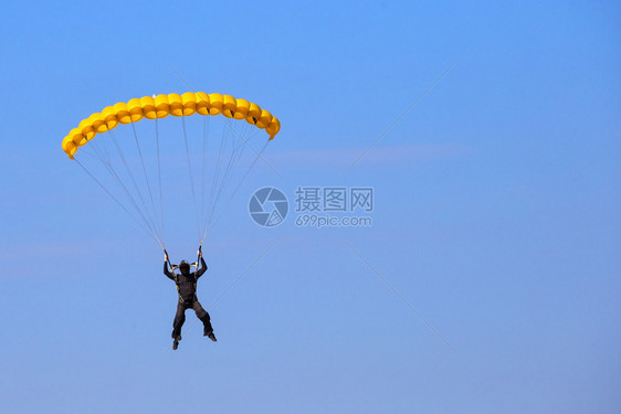 云Skydiver蓝天有黄色降落伞贸易标记和志被去除面罩藏在头盔具背后蓝天有黄色降落伞自由脸图片