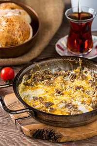 土耳其人用卡武尔马和土耳其黑茶炒鸡蛋木头美味的晚餐图片