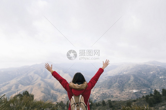 机器丰富多彩的织物向后看女人背着包抬起她的手臂俯视山地景观美丽的照片后仰望女人用背着她举起的手图片