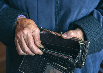 陈年金融一位老妇女手中的空钱包贫穷概念浅露深处的田地贫困图片