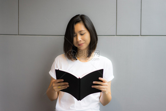 漂亮的成人亚洲年轻裔女阅读快乐图片