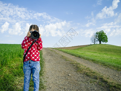 年轻女孩在瑞士农村有一台大相机在拍摄风景时下照片年轻的远足丘陵图片