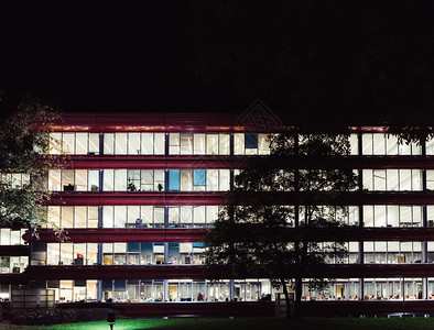 现代的排夜间空办公大楼噪音减少的办公大楼仍然有灯光夜间空办公大楼灯亮会议图片
