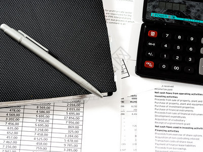 报告桌上记事本的计算器笔与财务文件桌上具有业务属财文件书纸图片