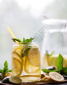 水果透明罐中的冷鲜柠檬水与角和木制背景上的薄荷透明罐中的冷鲜柠檬水与角和薄荷鸡尾酒新鲜图片