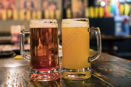 眼镜寒冷的木头两杯啤酒放在吧的木桌边餐厅休息和喝酒的概念中两杯啤酒图片