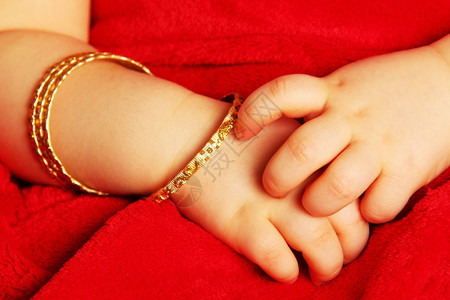 贝图姆黑暗的带着黄金手镯婴儿与黑暗红色隔绝手腕图片