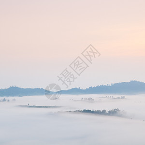 风景森林寒冷的清晨雾笼罩山岳和树木太阳升起早晨图片