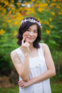 头发吸引人的美丽亚洲年轻女子带着一朵花的皇冠种图片