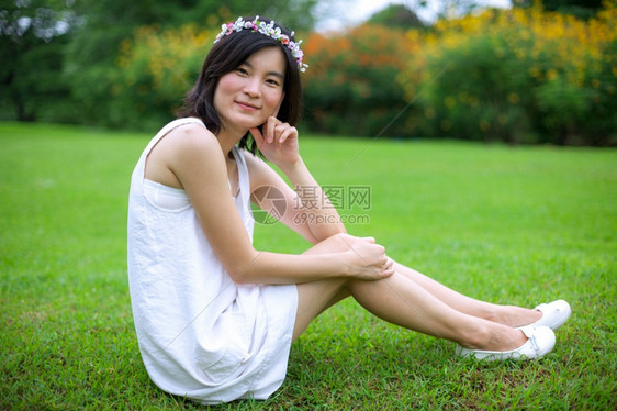 自然快乐的可爱美丽亚洲年轻女子带着一朵花的皇冠图片