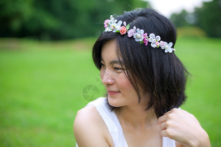 美丽的亚洲年轻女子带着一朵花的皇冠森林圈女士图片