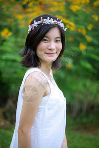 人们美丽的亚洲年轻女子带着一朵花的皇冠脸幸福图片