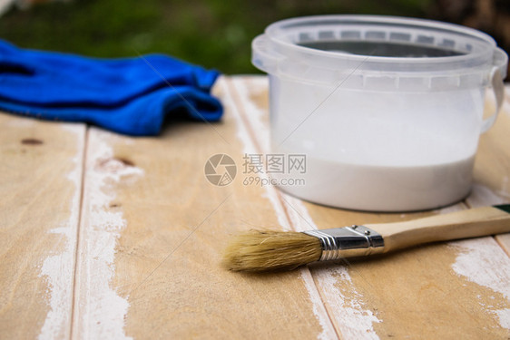 屋在室内建造油漆刷和板上有白色油漆的罐子为绘画概念准备木质表面油漆板的准备刷和板上有白色油漆的罐头为绘画概念准备木质表面图片