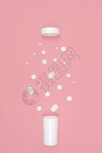 白药丸从瓶子里泼出粉红背景平板假肢概念与药丸的医学背景制药店片图片