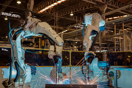 排团队机器人在工厂中焊接金属组件部分电子产品汽车图片