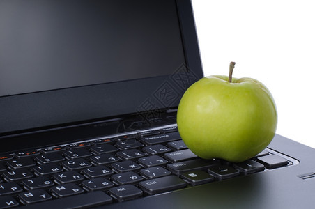 教育颜色电子商务笔记本脑键盘上的绿色苹果在白背景上被孤立图片