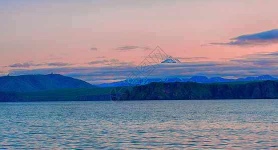 远的海岸卡姆恰特半岛日落时的Viluchinsky火山和Avacha湾美丽的图片