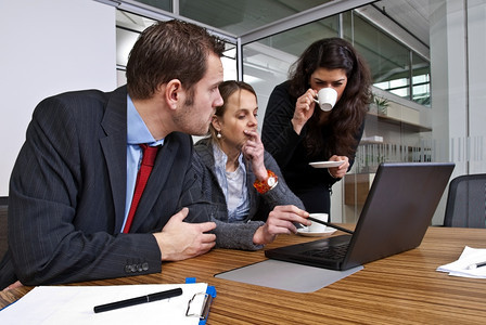 男团队三名工作人员在浏览笔记本电脑时讨论财务事项同时浏览笔记本电脑屏幕图片