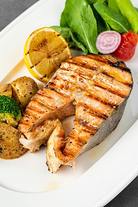 烤鲑鱼牛排和在黑石桌上的蔬菜美食三文鱼片图片
