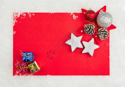 浪漫的喜庆锥体红圣诞纪念卡上面有小礼物盒和雪上星背景图片
