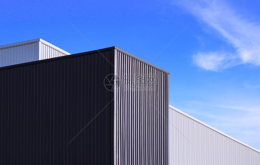 当代的黑色和白金属工厂建筑在蓝色天空背景下的低角度视图以蓝天背景为现代的白色图片