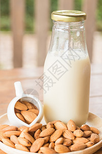 木制桌上的瓶装杏仁牛奶库存照片团体木制的营养图片
