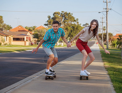 夜光在街上玩滑板快乐的哥姐和幸福的弟妹极端年轻的女士图片