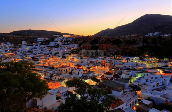 建筑学看着黄昏时的林多斯村屋顶海岸希腊语图片
