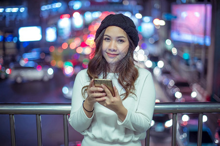 商业屏幕美丽的年轻亚洲女在夜间使用手机的户外肖像画女青年发短信图片