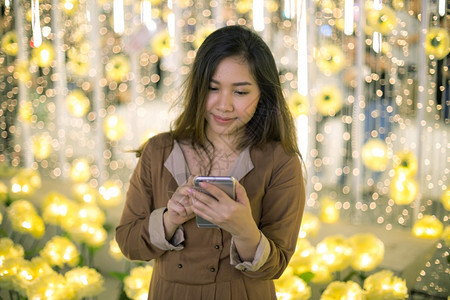 移动的发短信美丽年轻亚洲女在夜间使用手机的户外肖像画女青年晚上图片