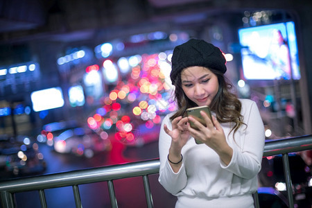城市商业美丽的年轻亚洲女在夜间使用手机的户外肖像画女青年沟通图片