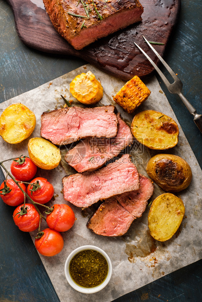 切碎烤牛肉在板上与烧烤蔬菜一起切割晚餐香料迷迭图片