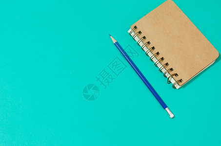 绿色背景的笔记本和铅笔图片