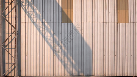 保护贮存时间深下午工厂建筑的金属板壁表面工业和建筑概念上古老的锈金属高架路标结构的光亮和阴影以及工业和建筑的概念图片
