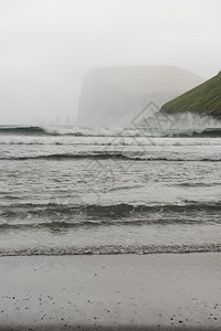 水瑞辛从丹麦欧洲法罗群岛StreymoyStreymoy的Tjornuvik湾看到海中的里辛和凯林金岩石多雾路段图片