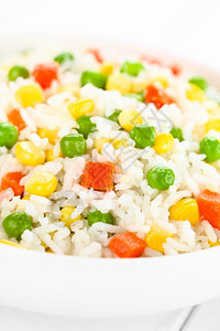 煮熟白米加多彩蔬菜洋葱胡萝卜绿豆玉米白碗的青豆选择焦点重13放入蔬菜饭里丰富多彩的脉冲垂直图片
