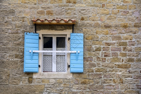 墙旧石屋上的蓝木窗百叶复古的白色图片