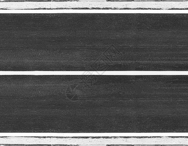 中间单身的白色条纹路面交通在公表的黑色纹理上背面是灰色的车道图片