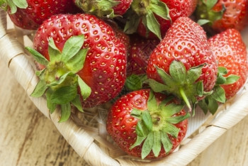 新鲜的吃栽培草莓水果躺在篮子里草莓水果放在篮子里从上层的草莓果子看出来的景象这篮子站在一个风湿的董事会上图片