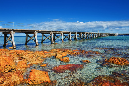 海面景观有木铁码头和橙色石块天空户外海岸图片