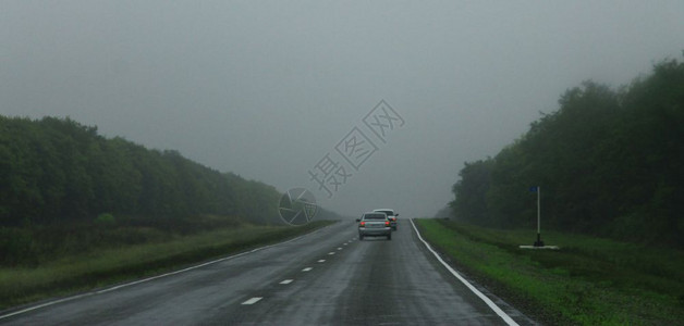 公路风景白天通过迷雾路行驶汽车白种人宽的草地背景图片