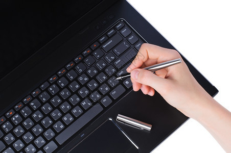 手持笔记本电脑键盘上的钢笔在白色背景上被孤立教育白色的银图片
