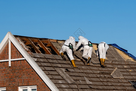 防护服专业人员除去石棉水泥屋顶的铺设内置布料危险建造工作图片